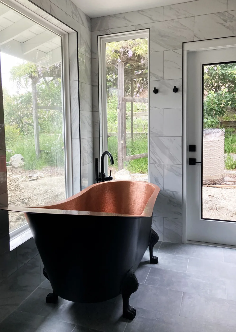 Copper clawfoot tub with marble surround